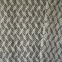 Detail of gray and white braided blocks wool blanket.