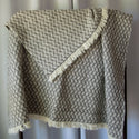 Gray and white wool blanket draped on rod.