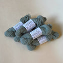 Five skeins of blue-green yarn dyed with hollyhock flowers.